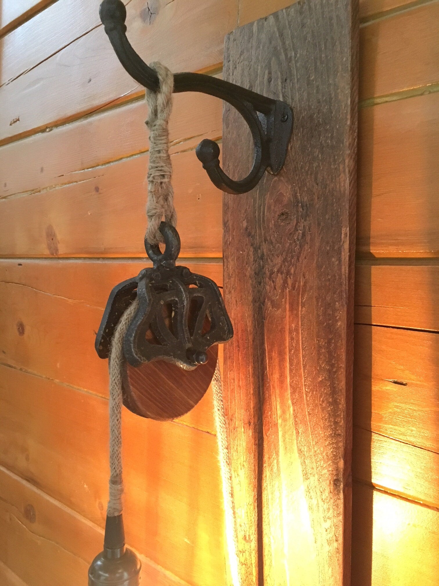 Wall sconce with metal pulley for country decor, cabin chic light fixture adds rustic charm, ideal blend of industrial and farmhouse vibe