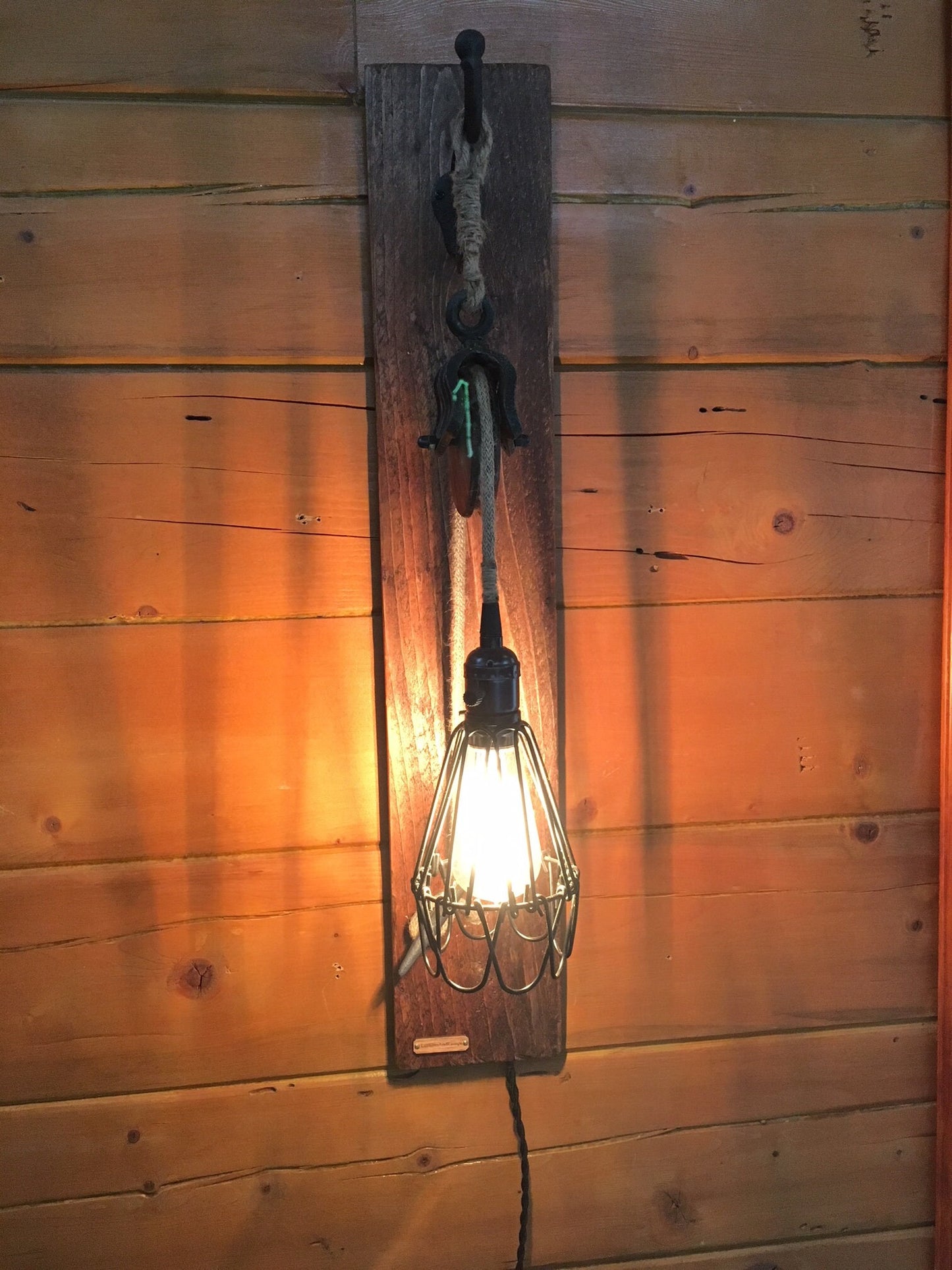 Wall sconce with metal pulley for country decor, cabin chic light fixture adds rustic charm, ideal blend of industrial and farmhouse vibe