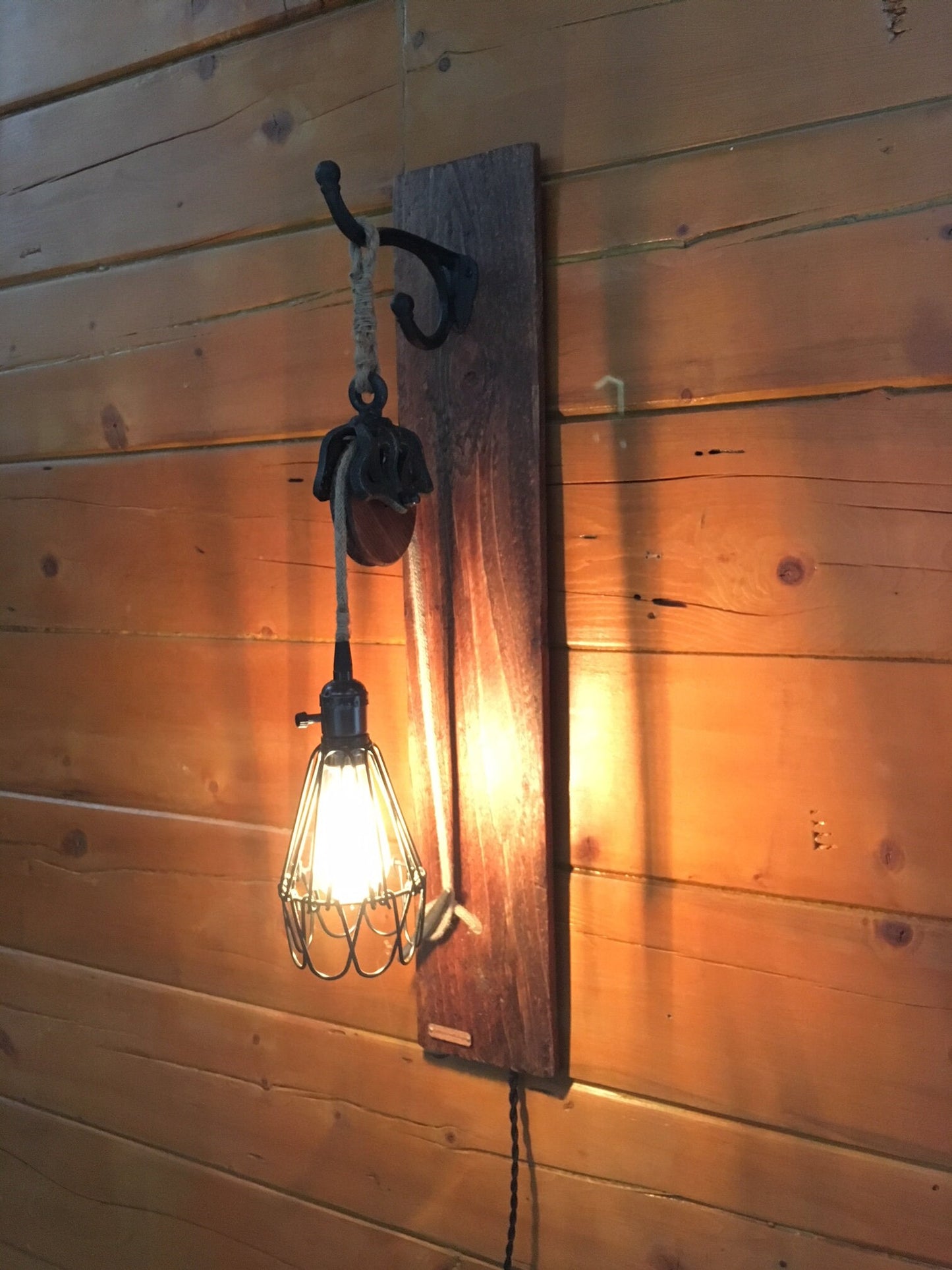 Wall sconce with metal pulley for country decor, cabin chic light fixture adds rustic charm, ideal blend of industrial and farmhouse vibe