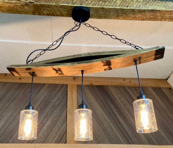 Unique ceiling pendant light from authentic bourbon barrels staves, ideal for bar or man cave, adds warmth and character