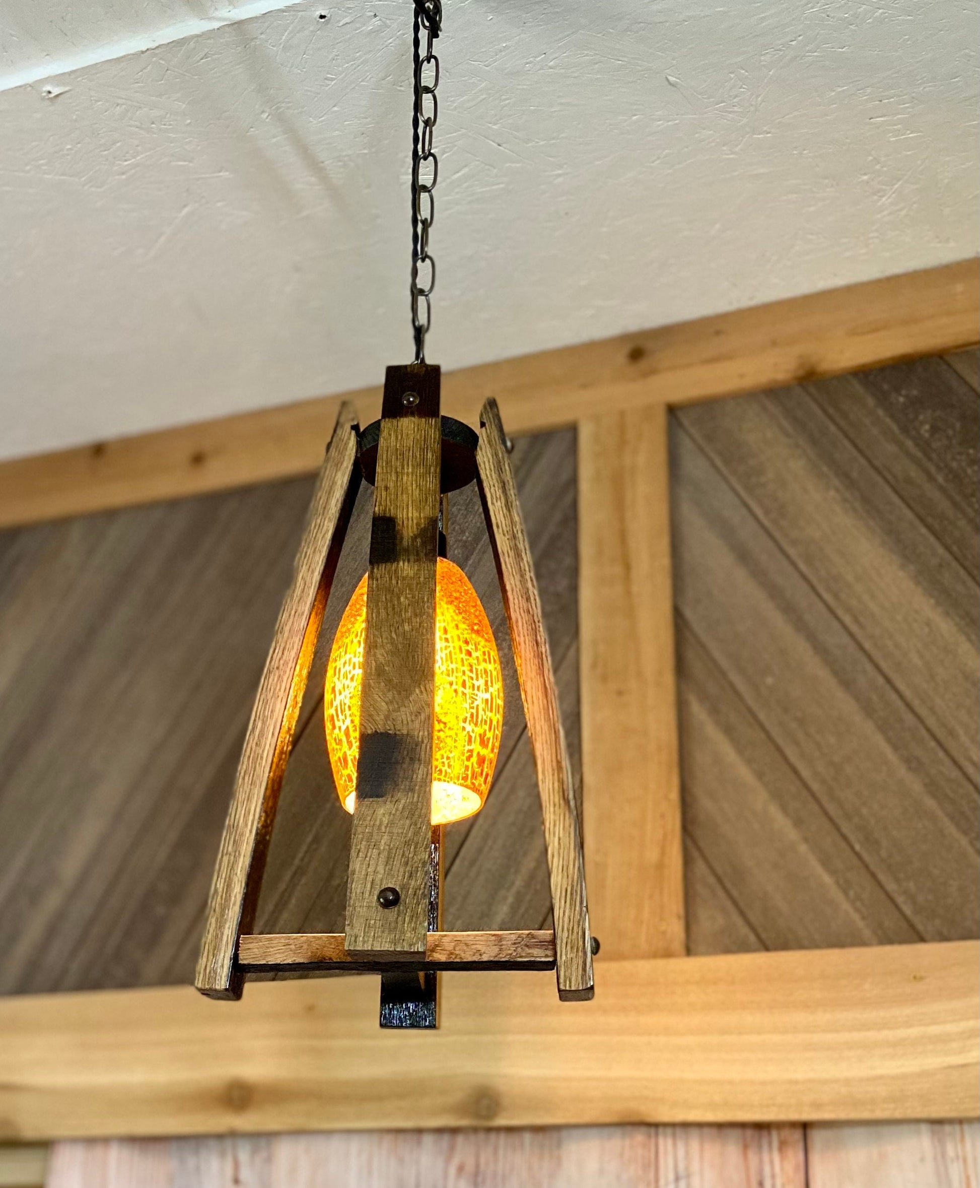 Handcrafted light fixture made from genuine barrel saves, accentuated by warm amber glass shade, perfect blend of rustic and elegance